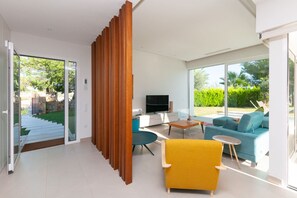 A modern living room with a sofa, a yellow armchair, and a TV. - Sisu Willa z Podgrzewanym Basenem Las Colinas Golf (Orihuela)