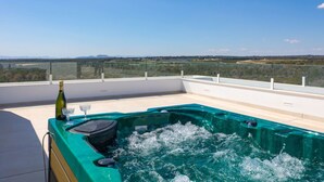 A hot tub on a balcony with a clear view of the landscape.