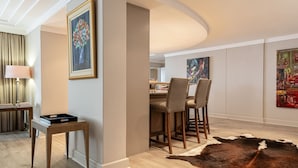 A modern dining area with a wooden table and chairs, a cowhide rug, and framed artwork on the walls. - Bantry Place - Luxury Apartment (Cape Town)