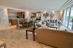 Una sala moderna con sofá, mesa de centro y comedor con sillas.