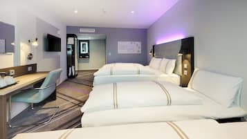 Habitación de hotel con escritorio, dos camas, una silla, televisión de pantalla plana y un reloj de pared.