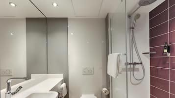 Un bagno moderno con doccia, servizi igienici e lavandino.