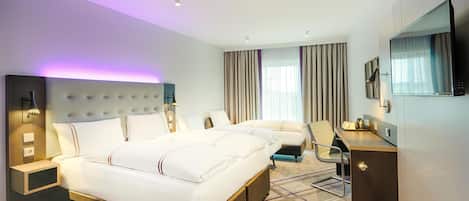 A modern hotel room with a large bed, a desk, a chair, a TV, and a bathroom.