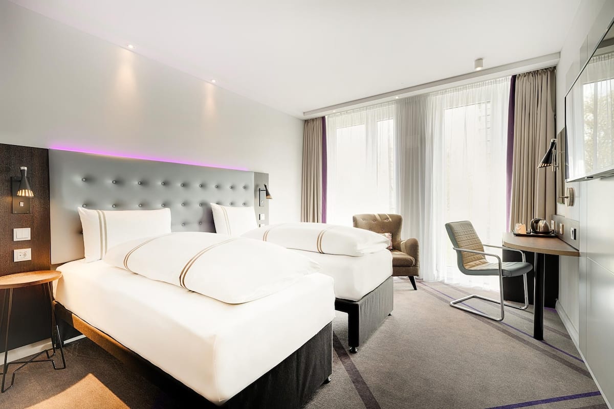 Una habitación de hotel con una cama grande, un escritorio, una silla y un televisor.