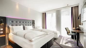 A hotel room with a large bed, a desk, a chair, and a TV.