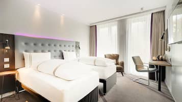Una habitación de hotel con una cama grande, un escritorio, una silla y un televisor.