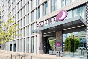 A modern building with a prominent Premier Inn sign, large windows, and a tree in front. - Premier Inn Berlin Alexanderplatz (Berlin)