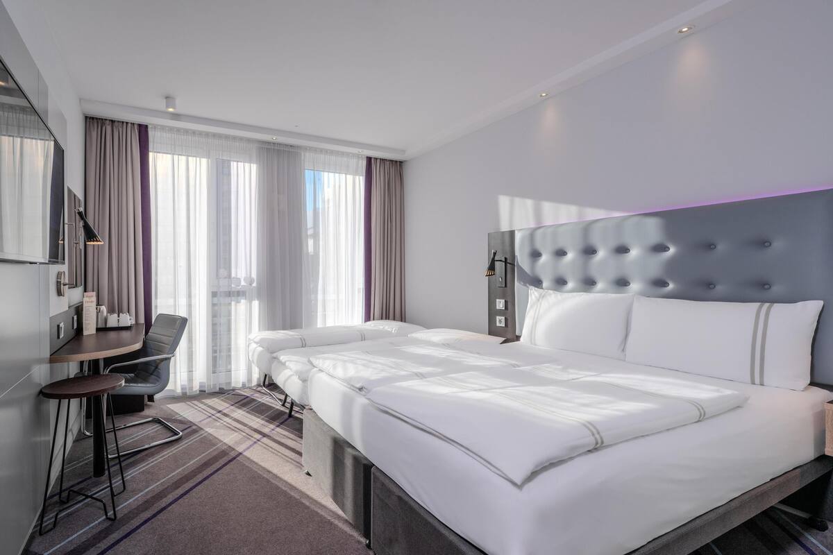 Una habitación de hotel moderna con una cama grande, un escritorio y una silla.