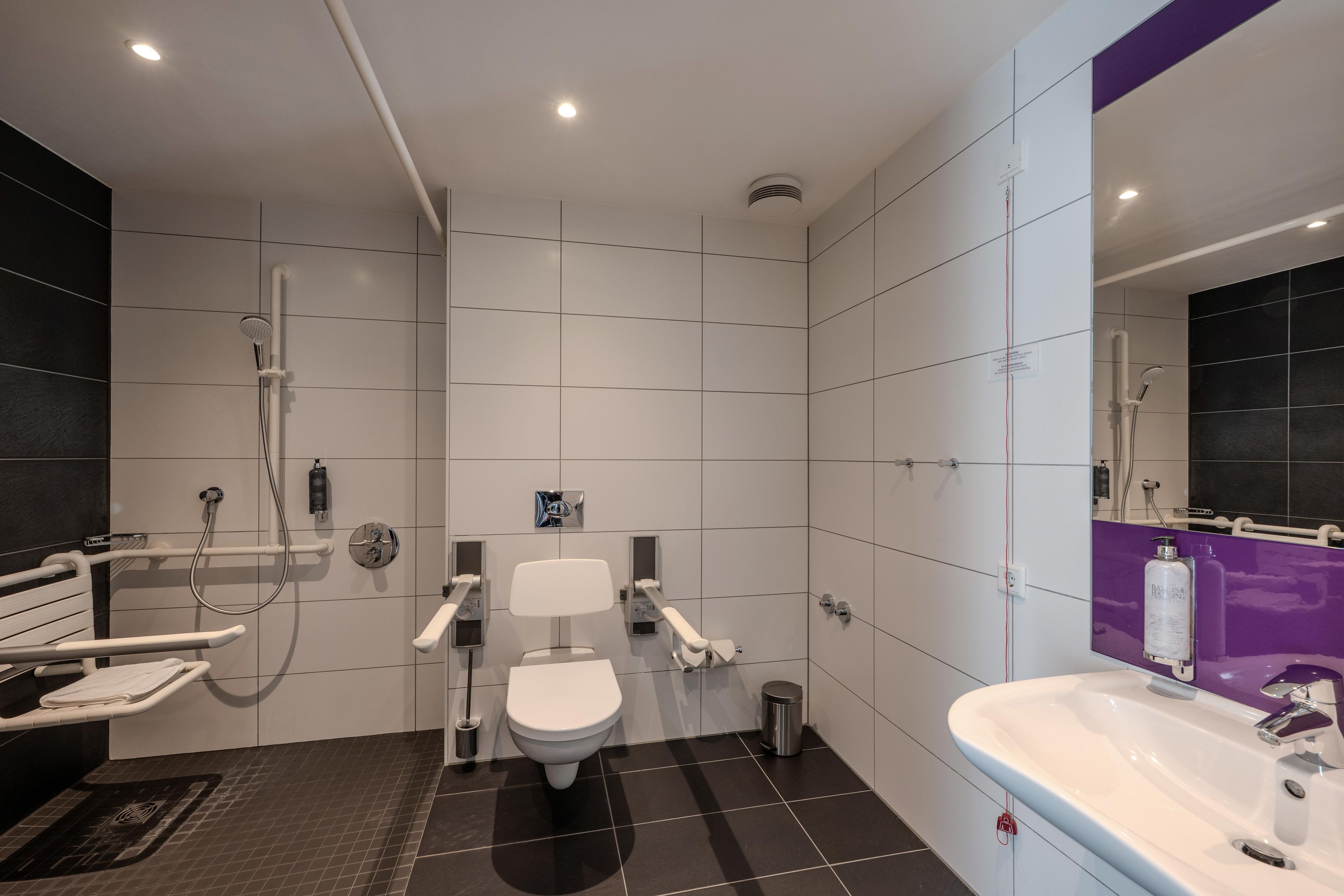 A modern bathroom with a toilet, bidet, shower, and sink.