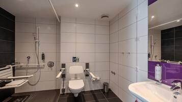 A modern bathroom with a toilet, bidet, shower, and sink.