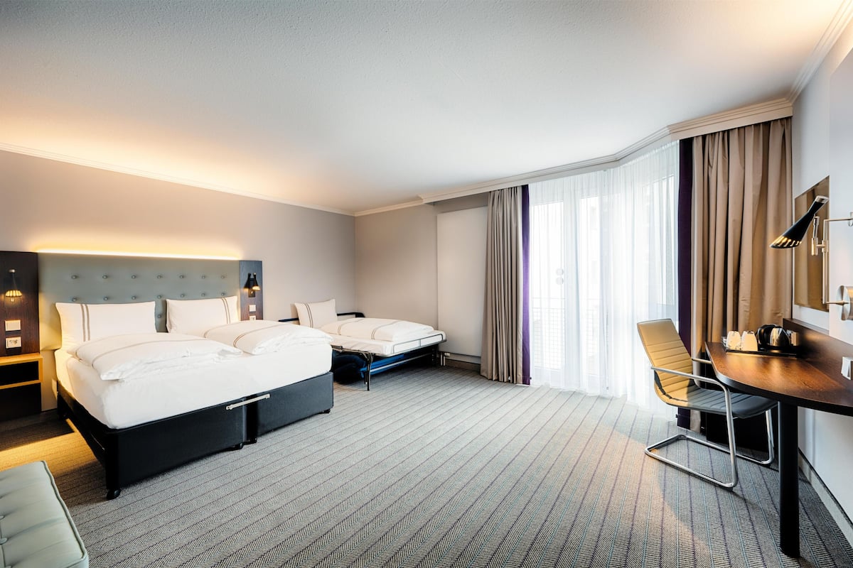 Habitación de hotel con dos camas, un escritorio y una silla.