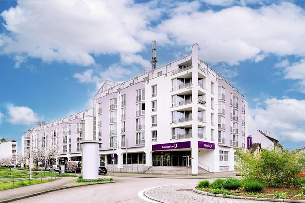 A multi-story hotel with a prominent entrance, a sign for Premier Inn, and a clear sky.