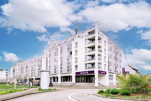 Un hotel de varios pisos con una entrada destacada, un letrero de Premier Inn y cielo despejado.