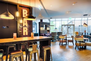 A bar area with stools, pendant lighting, and a 'BAR' sign.