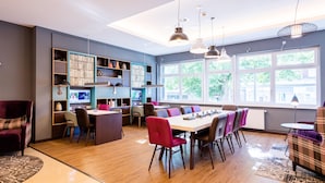 Un interior moderno con comedor, estanterías y ventanas amplias.