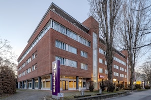 Un hotel de varios pisos con un llamativo letrero de 'Premier Inn', grandes ventanales y fachada de ladrillo.