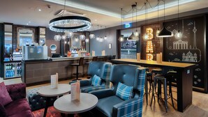 A modern bar area with seating, a counter, and a neon sign. - Premier Inn Berlin City Süd (Berlin)