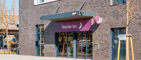 A Premier Inn hotel with a modern brick facade, large windows, and a visible entrance.