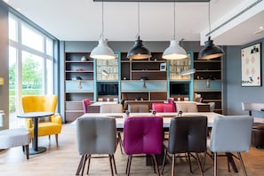 Un comedor moderno con una mesa grande, varias sillas e iluminación colgante.