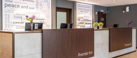 A hotel reception desk with a large sign displaying words like 'peace,' 'quiet,' and 'sleep.'