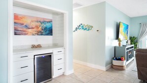 Ein Wohnzimmer mit Fernseher an einer weißen Wand, Kamin und einer dekorativen Wandgestaltung.