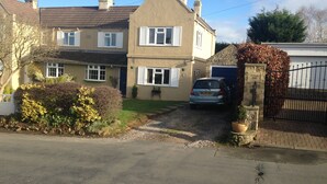 A two-story house with a driveway leading to a garage. - Room-large Home in Prime Location for al (Wetherby)