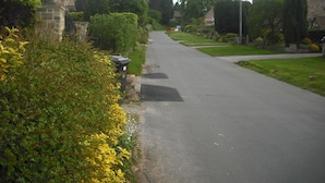 A quiet residential street lined with houses and greenery. - Room-large Home in Prime Location for al (Wetherby)