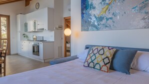 A bedroom with a bed, pillows, and a painting on the wall. - Il Nido sul Lago by Varenna Holidays (Perledo)