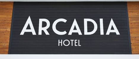 A sign for the Arcadia Hotel with a modern design, featuring a black background and white lettering.