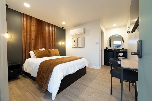Un dormitorio moderno con una cama grande, un escritorio y una silla.