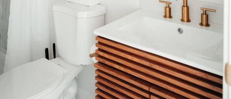 Un baño moderno con inodoro, lavabo y ducha.