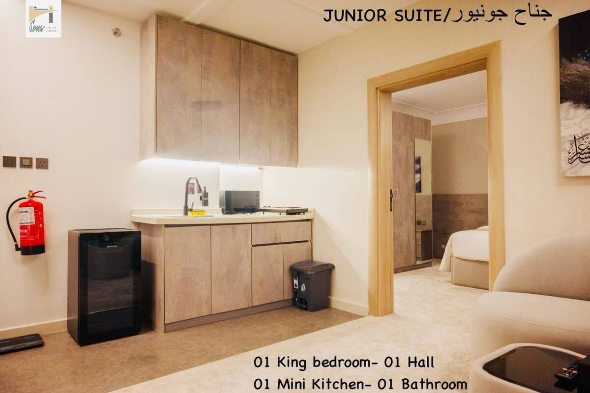 Une suite de catégorie inférieure comprenant une chambre avec un grand lit, un hall, une kitchenette et une salle de bain.