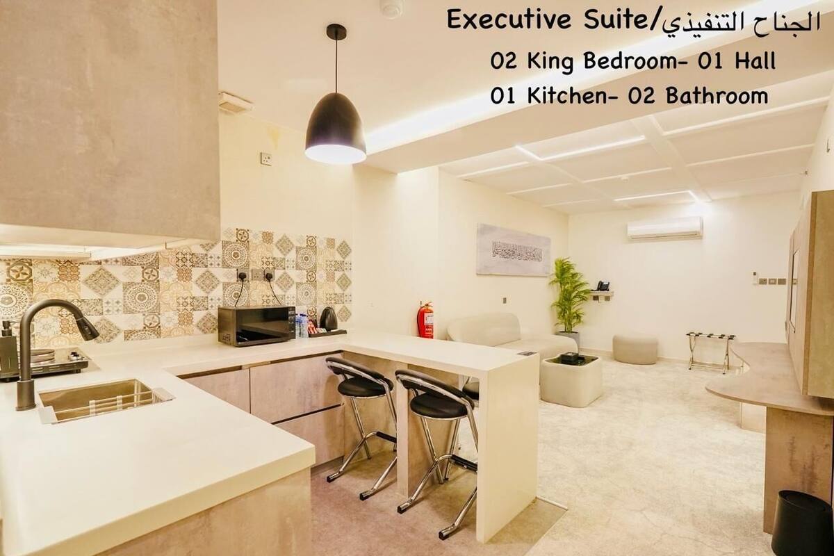 Une suite moderne pour cadres, comprenant une cuisine, un coin repas et une petite salle de bain.