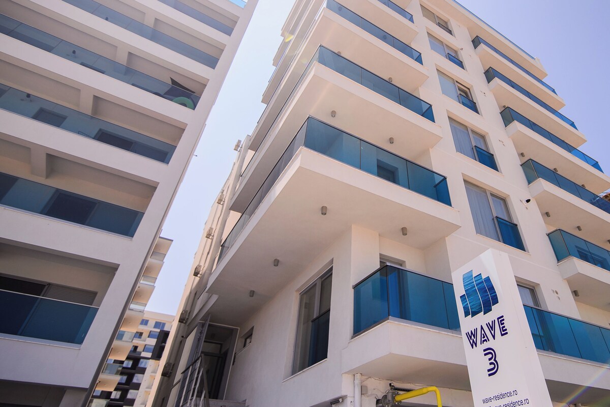 Un immeuble à plusieurs étages doté d’une architecture moderne, avec des balcons et de grandes fenêtres.