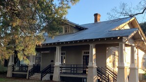 A two-story house with a porch, columns, and a staircase leading to the front door. - Downtown Historic home steps away from Festival International (Lafayette)