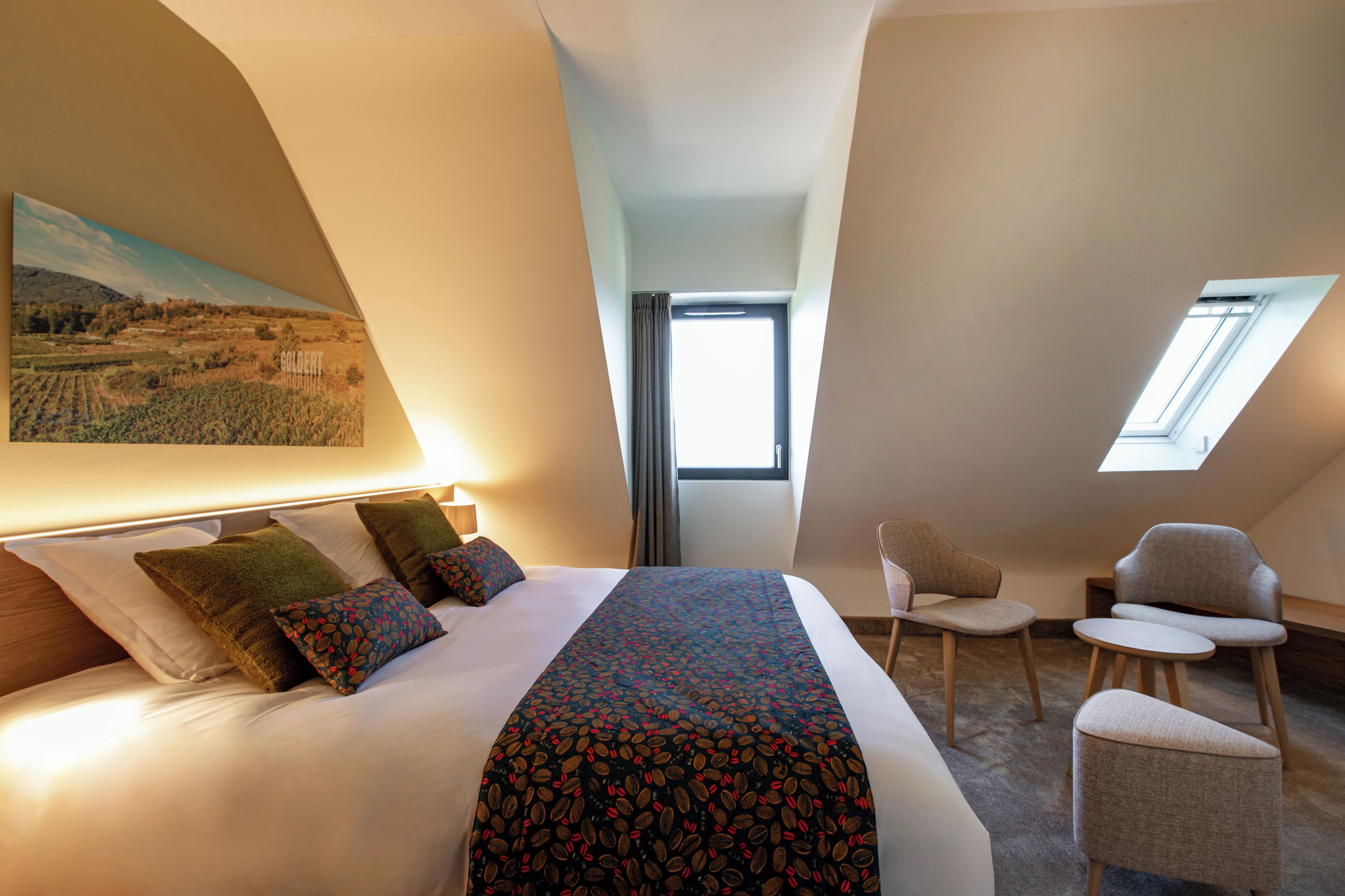 Una habitació d'hotel amb un llit gran, un escriptori i un fanal.