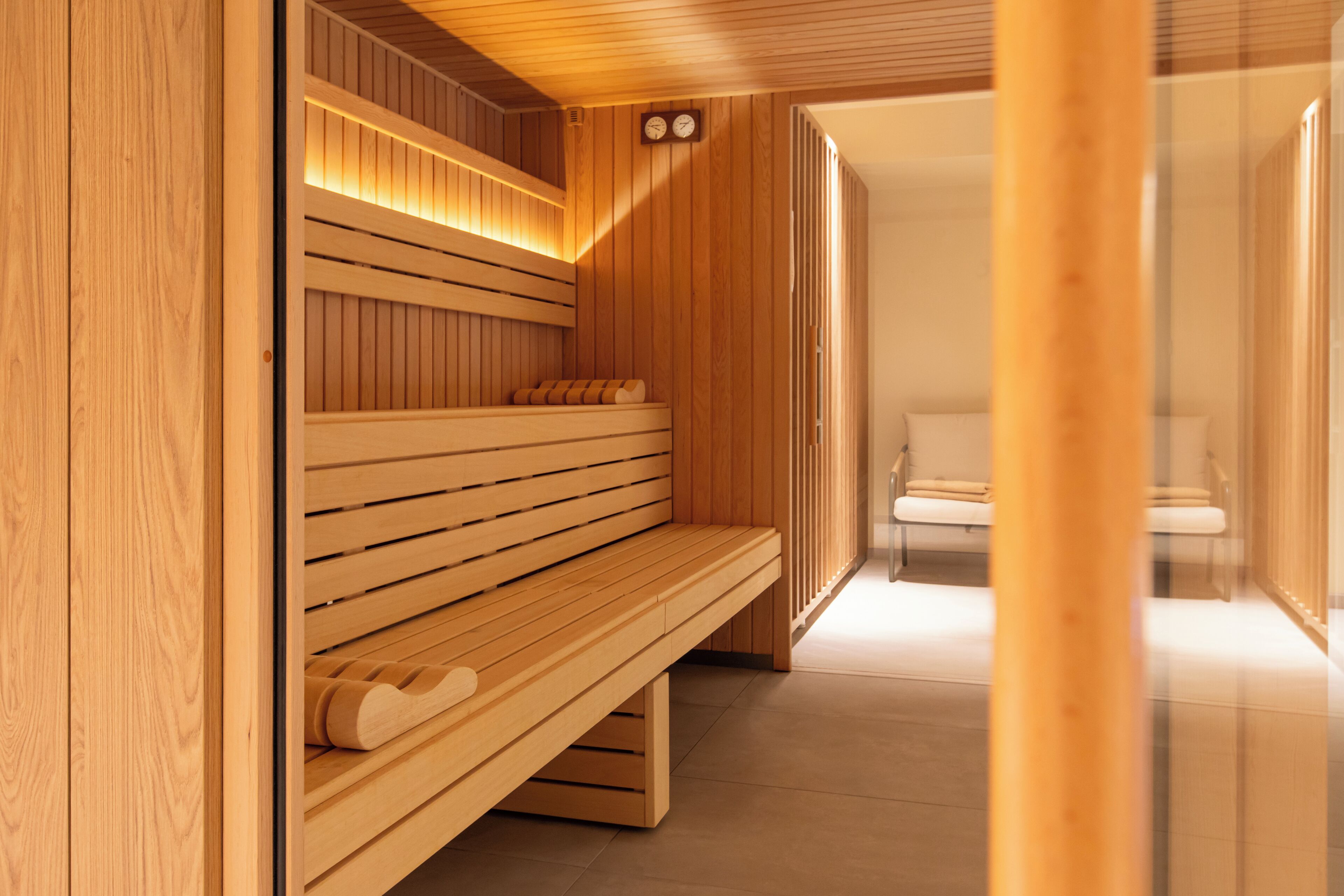 A wooden sauna with benches and a bench with a heart-shaped cutout.