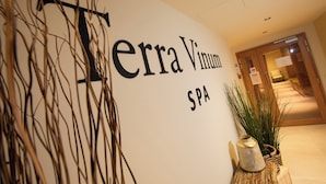 Segnaletica per Terra Vinum Spa con una pianta decorativa e un vaso su un supporto in legno.