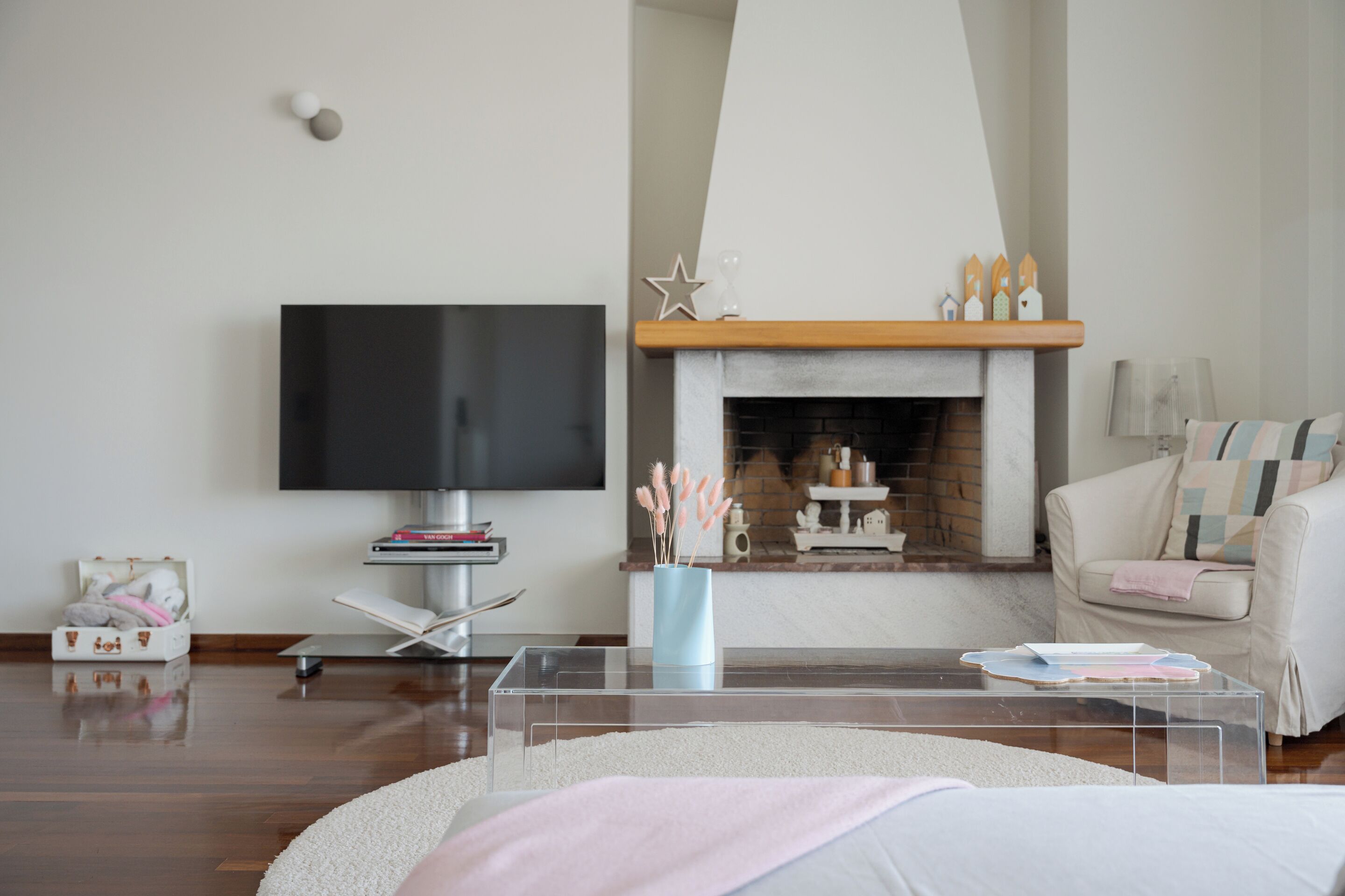 A modern living room with a flat-screen TV, a fireplace, a sofa, and a coffee table.