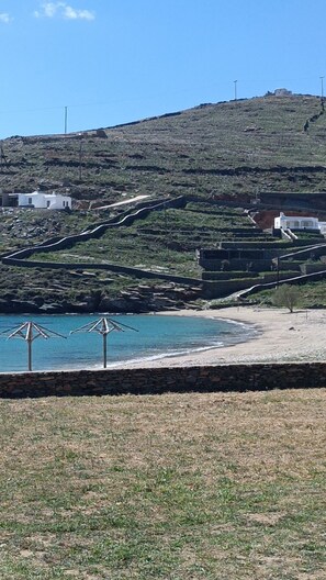 A coastal landscape with a hillside, a beach, and a few buildings. - Simousi Studio 1 sea View on the Beach (Kithnos)