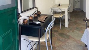 A compact room with a desk, chair, and a flat-screen TV mounted on the wall. - Simousi Studio 1 sea View on the Beach (Kithnos)