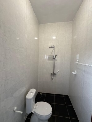 Een douche, handdoeken, zeep, toiletpapier