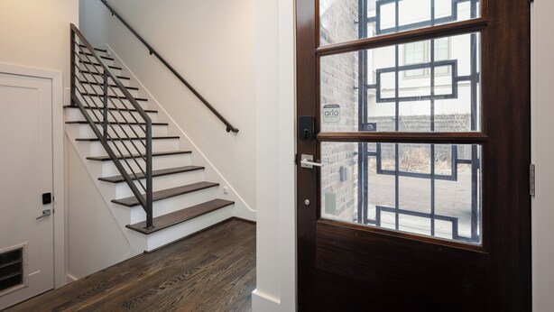 A staircase with a metal handrail leading to a white door. - Space City - Prof. Design, Game Room, King BD (Houston)