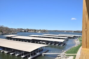 A marina with multiple docks and boats, surrounded by water and buildings in the background. - Waterfront -Wifi -2 Pools/Sandy Beach/Great Location- Grill- Boat slip available (Osage Beach)