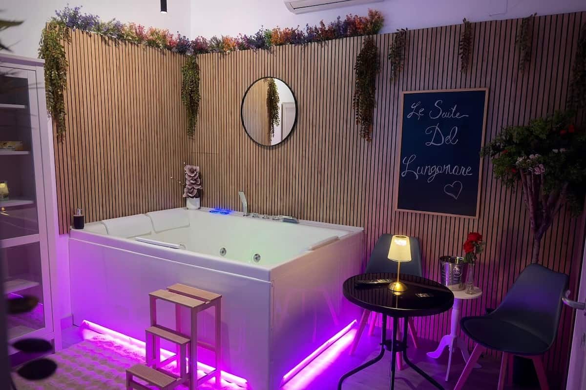 Un baño moderno con una bañera independiente, un tocador, un espejo y un cartel que dice "Le Suite Lungsone".