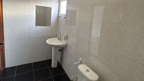 Ein Badezimmer mit Toilette, Waschbecken und Spiegel.