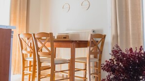 Un comedor con una mesa y sillas de madera, un radiador y adornos en la pared.