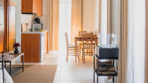 Una cocina moderna y bien iluminada con armarios de madera, un comedor con mesa y sillas, y vistas al exterior a través de grandes ventanales.