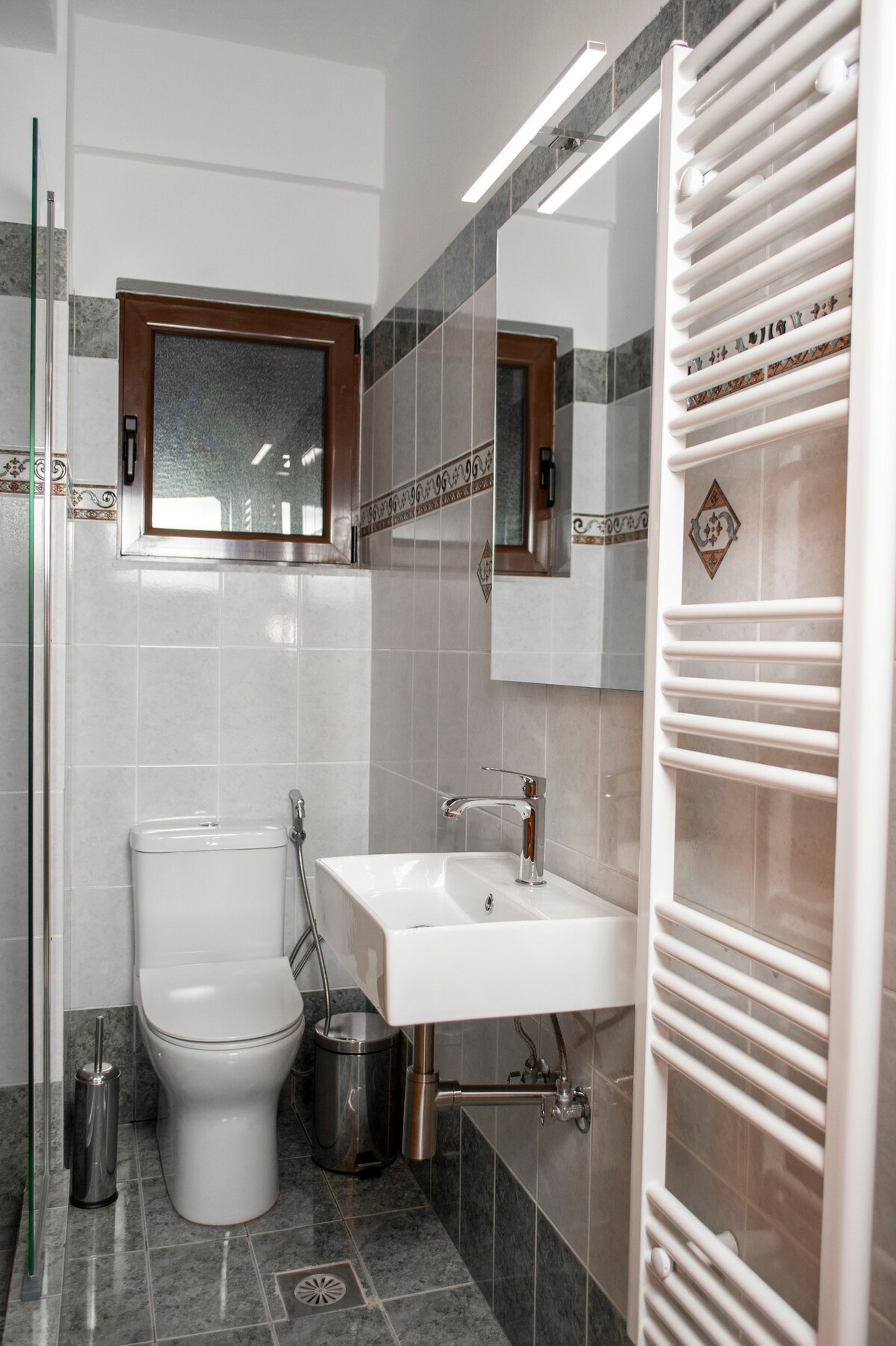 A modern bathroom with a toilet, sink, and shower.