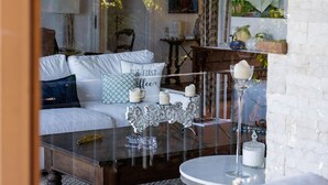 Ein gemütliches Wohnzimmer mit einem weißen Sofa, einem runden Couchtisch und einer Glastreue.